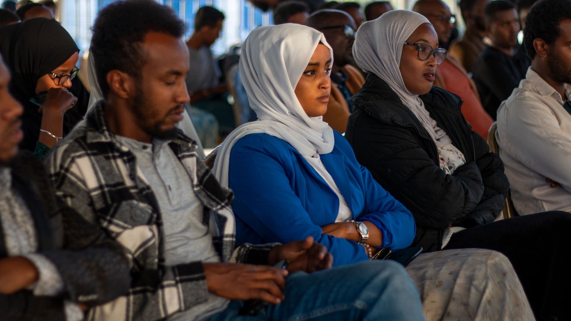 Rows of people seated together, listening